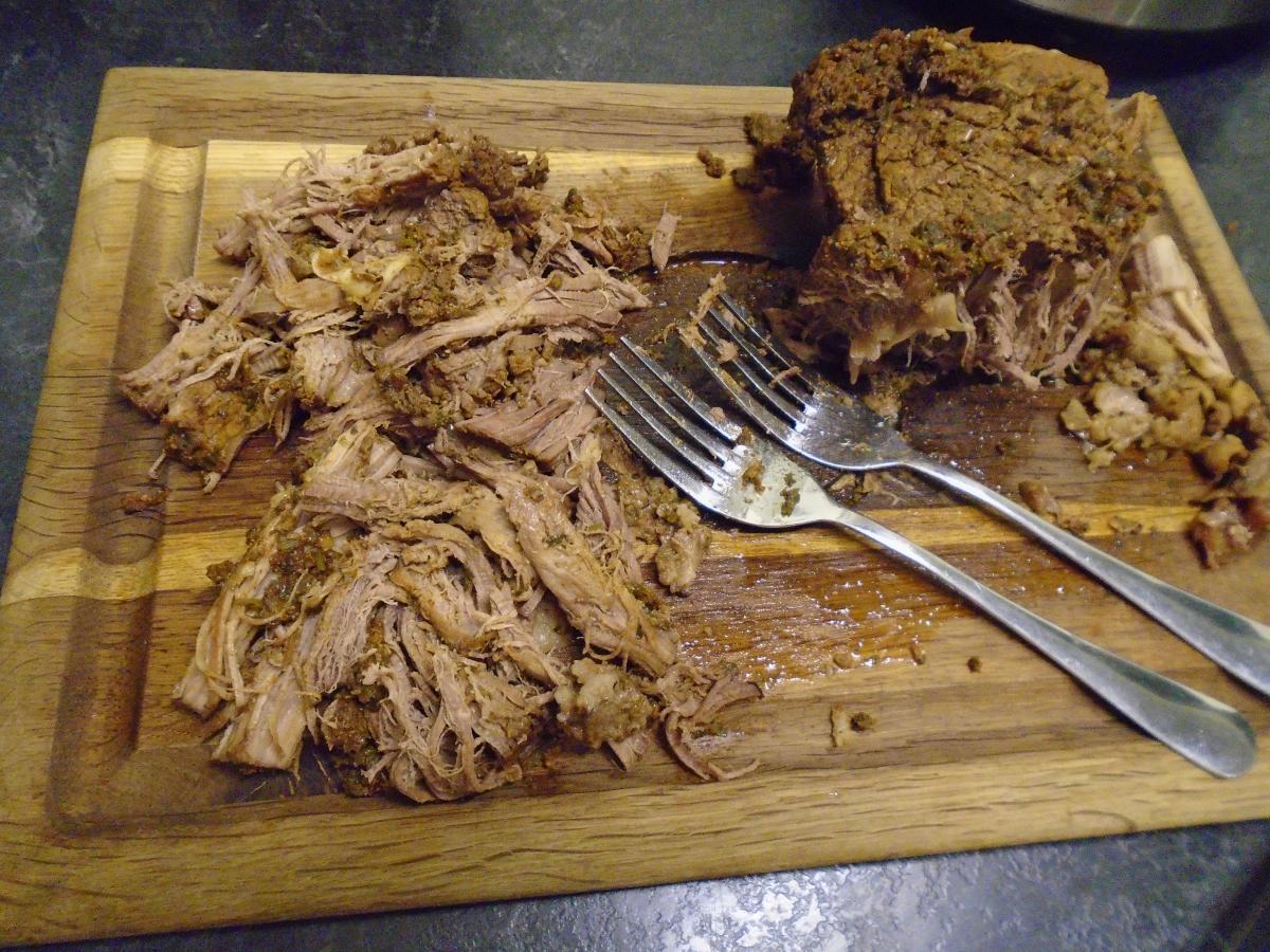 After the time's up, remove the meat from the slow cooker and shred into pieces with two forks