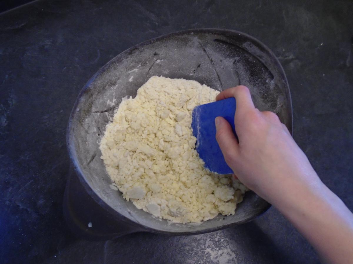 Add 2 tbsp ice cold water and use a dough scraper or a knife to “cut” the liquid through the mixture