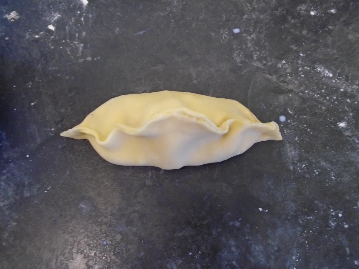 Pull opposite sides up over the filling, using the water to stick the pastry together all the way round