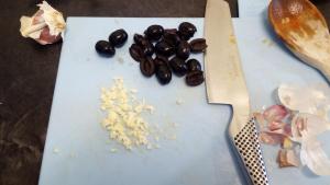 Halve 12–15 olives and finely chop 2 garlic cloves